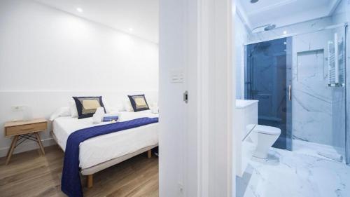 Un dormitorio con una cama y un baño con ducha. en Central Luxury Boutiques I - SSHousing, en San Sebastián