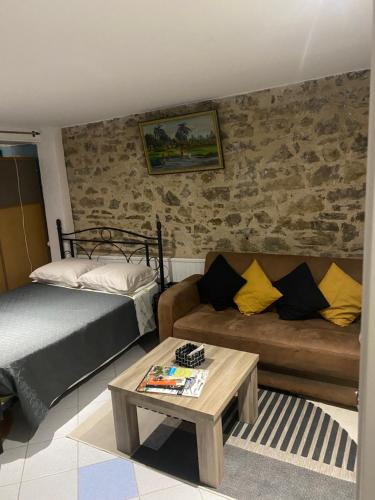 a bedroom with a bed and a couch and a table at La casa du port, Chambres, suite privée, appartement avec vue sur la rivière in Capdenac