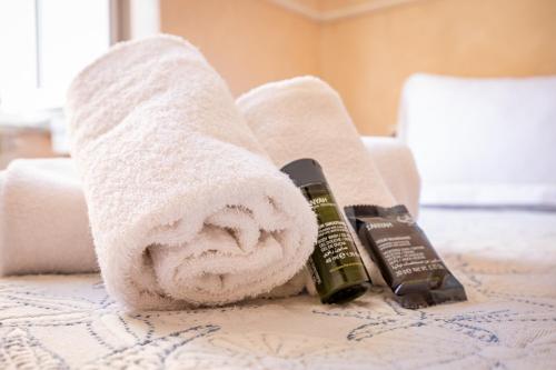 a towel on a bed with a bottle of alcohol at Alla Marina Affittacamere in Riomaggiore