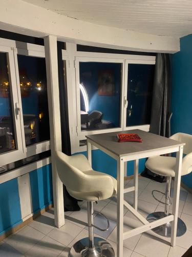 a table and chairs in a room with a window at La casa du port, Chambres, suite privée, appartement avec vue sur la rivière in Capdenac