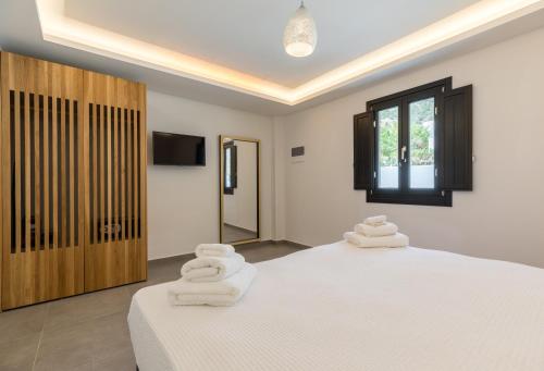ein Schlafzimmer mit 2 Betten und weißen Handtüchern darauf in der Unterkunft Nostos Apartments Kamari in Kamari