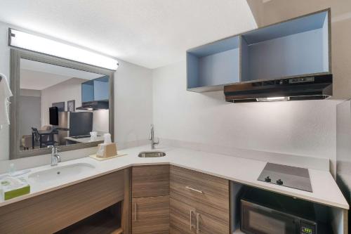 a kitchen with a sink and a mirror at Suburban Studios in Cleveland