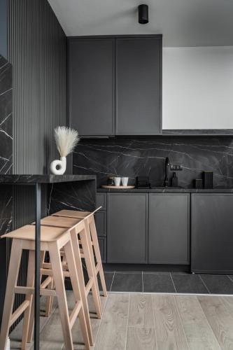 a kitchen with black cabinets and a table and chairs at Marrilux apartments Residence Hill in Kopaonik