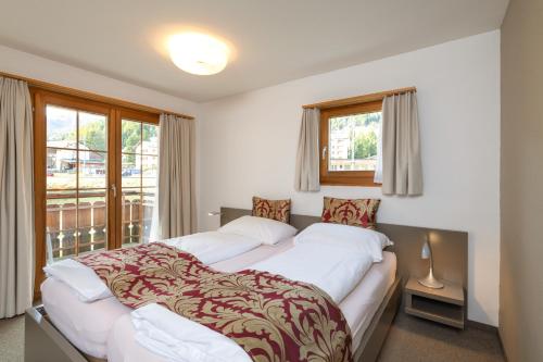 1 Schlafzimmer mit 2 Betten und einem Fenster in der Unterkunft Hotel Allegra in Zuoz