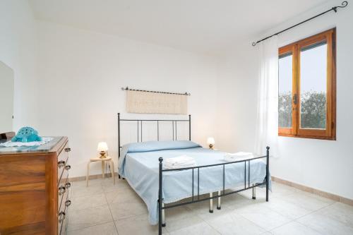 een slaapkamer met een bed, een ladekast en een raam bij Villa Francesco P Terra in Orosei