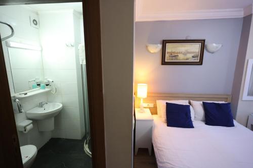 a bedroom with a bed and a sink and a toilet at Arven Hotel in Istanbul