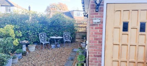 a patio with chairs and a table in a garden at The Studio @ Michael House in Horley