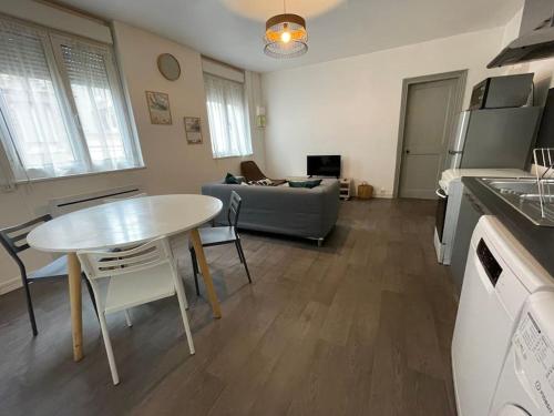 une cuisine et un salon avec une table et un canapé dans l'établissement Appartement 2 chambres à 3 min à pied de la plage, à Saint-Valery-en-Caux