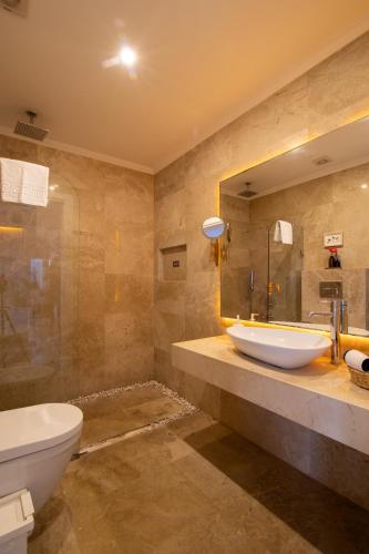 a bathroom with a sink and a toilet and a mirror at Villa Ilda - Deluxe Holiday Villa - KALKAN-ANTALYA in Kalkan