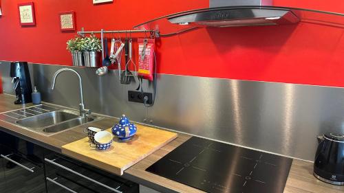 ミッデルケルケにあるZeedijk Westende 8p Appの赤い壁のキッチン(ステンレス製のシンク付)