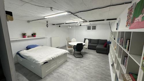 ミッデルケルケにあるZeedijk Westende 8p Appのベッドルーム1室(ベッド1台、テーブル、ソファ付)