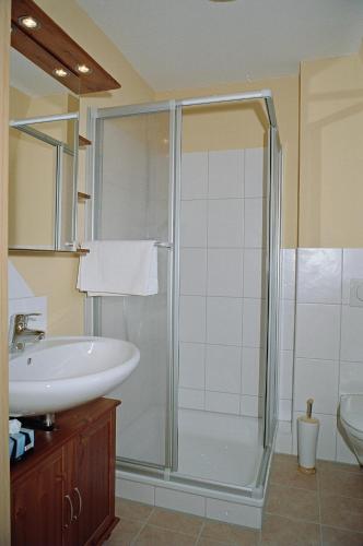 a bathroom with a shower and a sink at Hotel "Pension" Strandkorb in Norddeich