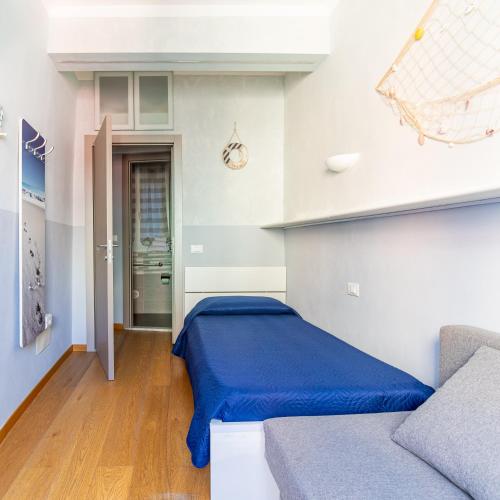 a bedroom with a blue bed and a couch at Alla Marina Affittacamere in Riomaggiore
