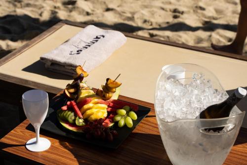 a table with a plate of fruit and a bottle of wine at Olympic Star Beach Hotel in Nei Poroi
