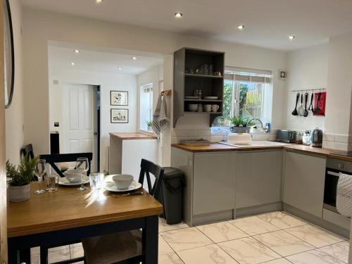 a kitchen with a wooden table and a dining room at 42 Church Row - 2 beds and 2 bathrooms in Bury Saint Edmunds