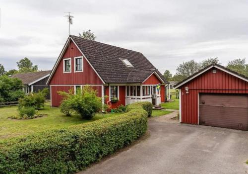 a red house with a garage and a driveway at Smålandshus in Målilla