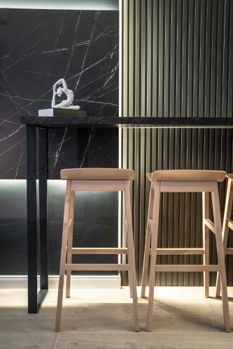 a black table with two wooden chairs next to it at Marrilux apartments Residence Hill in Kopaonik