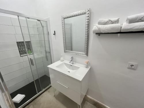a white bathroom with a sink and a shower at CAMASanlúcar in Sanlúcar de Barrameda