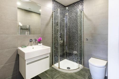 La salle de bains est pourvue d'une douche, d'un lavabo et de toilettes. dans l'établissement Central London Large 3bed 2bath with massive terrace overlooking grand union canal. (8 occupancy), à Londres