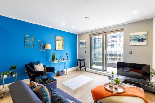 a living room with a blue wall at Central London Large 3bed 2bath with massive terrace overlooking grand union canal. (8 occupancy) in London