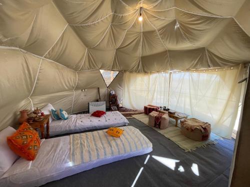 a bedroom with two beds in a tent at Eagles Dôme in Bou Tferda