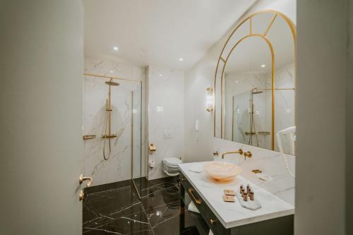 a bathroom with a sink and a toilet and a mirror at Sungarden Golf & Spa Resort in Cluj-Napoca