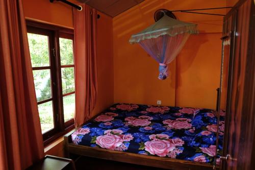 a bedroom with a bed with flowers and an umbrella at MENAKA HOMESTAY in Tangalle