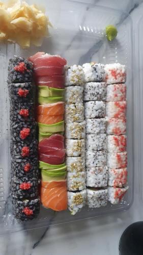 a refrigerator filled with different types of sushi at Sarajevo Charm Apartment in Sarajevo