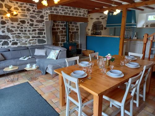 a living room with a wooden table and a couch at Gites et Cocon des Puys in Nébouzat