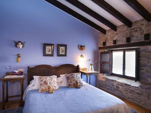 a bedroom with a bed with a teddy bear on it at Hotel Rural Zalama in San Pelayo - Merindad de Montija