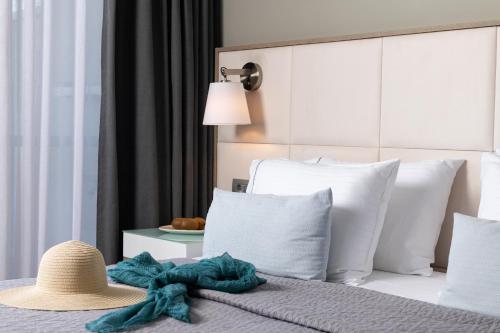 a bed with a hat and pillows and a table at Olympic Star Beach Hotel in Nei Poroi