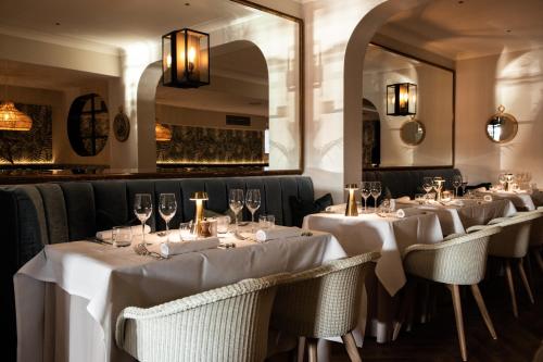 une rangée de tables dans un restaurant avec des nappes blanches dans l'établissement The Moorings Hotel & Restaurant, à Gorey