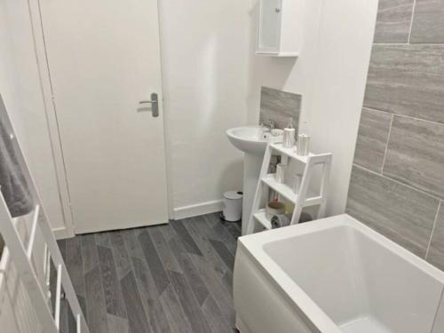 a bathroom with a sink and a tub and a toilet at Reconnect with loved ones in this 3BD House in Lemington