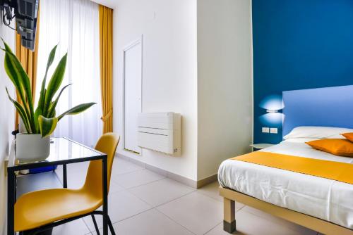 a bedroom with a bed and a table and a chair at V10 GUESTHOUSE - Vanvitelli 10 in Naples
