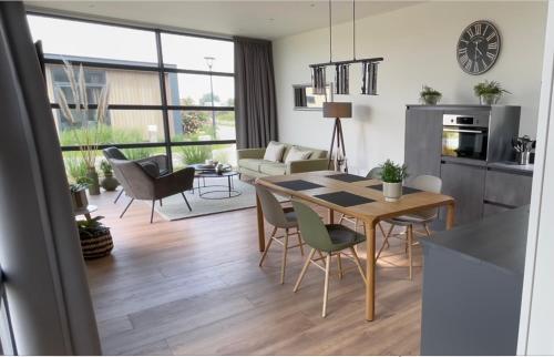 een keuken en een woonkamer met een tafel en stoelen bij Chalet Sunrise Vierte Reihe Haus Nr 218 in Enkhuizen