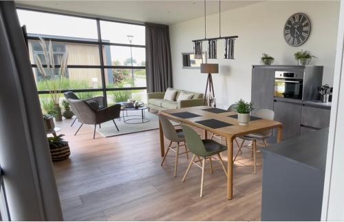 a kitchen and living room with a table and chairs at Chalet Sunrise Vierte Reihe Haus Nr 218 in Enkhuizen
