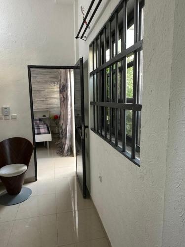 een hal met een spiegel, een stoel en een raam bij Baï résidence in Cotonou