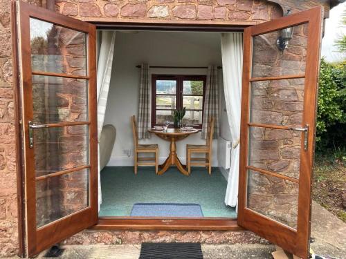 an open door to a dining room with a table at Peaceful Open-Plan Cottage With A View in Wellington