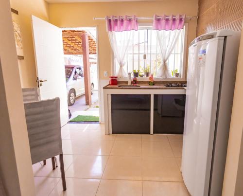 uma cozinha com um frigorífico, uma mesa e uma janela em Otimo flat a 750m do mar Sta Monica Guarapari ES em Guarapari