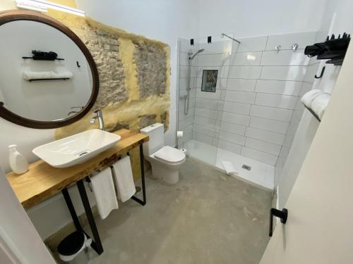 a bathroom with a sink and a toilet and a mirror at CAMASanlúcar in Sanlúcar de Barrameda