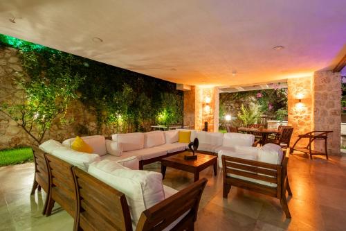 a living room with white furniture and a wall with plants at Villa Ilda - Deluxe Holiday Villa - KALKAN-ANTALYA in Kalkan