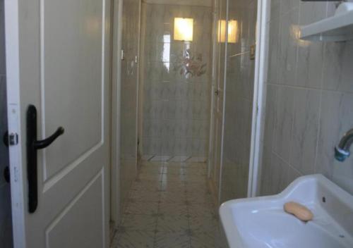 a white bathroom with a shower and a sink at MB SWEET HOME DJERBA in Houmt Souk