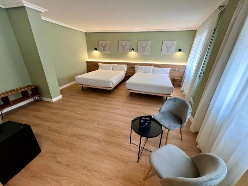 Habitación hospitalaria con 2 camas y sillas en Yomo Imperial, en Sant Julià de Lòria