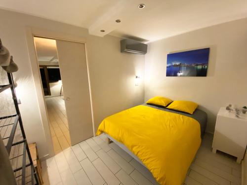 um quarto com uma cama amarela num quarto em Superbe 2 pièces TERRASSE / PISCINE / VUE / PARKING em Nice