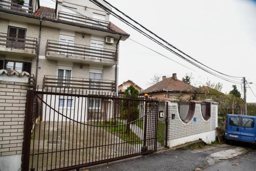 a fence in front of a building with a house at L & S BANJICA in Belgrade
