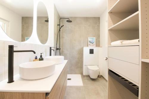 łazienka z dwiema umywalkami i toaletą w obiekcie Chalet Béchar Le Magnifique- Garden - Sauna & Jacuzzi w mieście Les Bossons