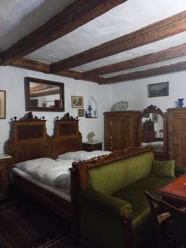 een slaapkamer met een bed, een bank en een spiegel bij LA Amadeus & Monica in Miniş