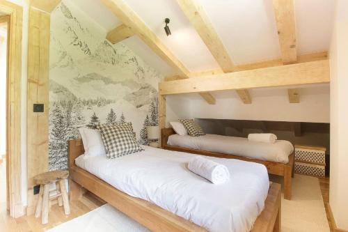 dwa łóżka w pokoju z malowidłem ściennym w obiekcie Chalet Béchar Le Magnifique- Garden - Sauna & Jacuzzi w mieście Les Bossons