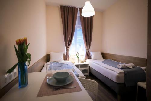 ein Zimmer mit 2 Betten und einem Tisch mit einer Schüssel darauf in der Unterkunft East Station Comfort Plus in Budapest