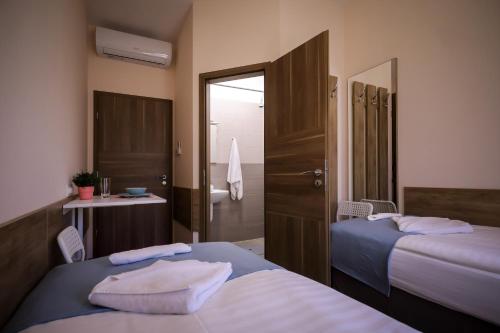 a hotel room with two beds and a bathroom at East Station Comfort Plus in Budapest